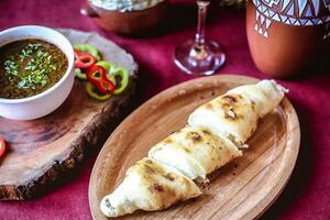 en bois assiette avec nourriture et bol de salsa photo