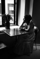 une fille avec une court la Coupe de cheveux dans une restaurant, noir et blanc photo dans ancien style