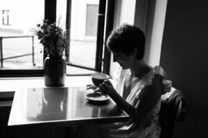 une fille avec une court la Coupe de cheveux dans une restaurant, noir et blanc photo dans ancien style