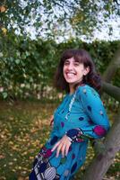 fille dans une robe avec des ballons sur une balançoire dans un l'automne jardin photo