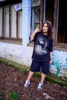 une adolescent fille dans noir vêtements dans grunge style photo