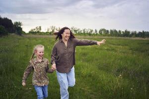 mère et les enfants courir en portant mains dans le champ photo