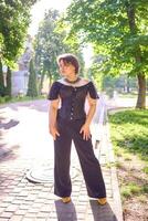 une moyen Taille femme dans une noir corset et large jambe pantalon des promenades par le ville dans le Matin lumière photo