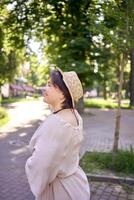 plus Taille femme dans pêche duvet robe avec chapeau ayant amusement sur Matin ville des rues photo