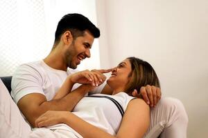 image de sucré couple dans l'amour et mari émouvant nez de le sien épouse photo