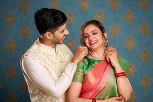 Indien romantique couple donnant Collier à le sien épouse sur diwali occasion photo