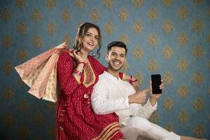 image de un adorable couple portant traditionnel Indien tenue en portant une assiette de ladoos dans leur mains et sourire photo