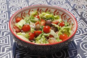 vert salade avec Cerise tomates, Olives, oignon, Frais herbes, citron jus et olive pétrole photo