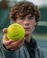 Jeune Masculin tennis joueur en portant une tennis Balle photo