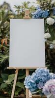 une blanc Vide horizontal affiche sur chevalet dans de face de mariage accueil les tables avec pastel bleu et violet couleurs hortensia fleurs photo