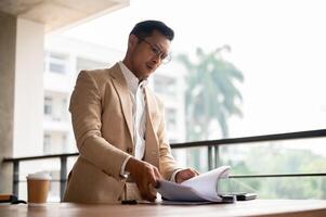 une déterminé asiatique homme d'affaire recherche pour une document, concentrer sur une document sur une tableau. photo