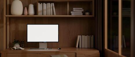 une moderne Accueil Bureau espace de travail dans le soir avec une Écran blanc ordinateur maquette sur une en bois bureau. photo