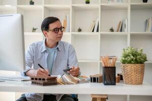 une professionnel Sénior asiatique Masculin intérieur designer ou architecte travail dans le sien moderne bureau. photo