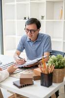 une Masculin intérieur designer ou architecte est ayant une réunion avec le sien client dans le bureau. photo