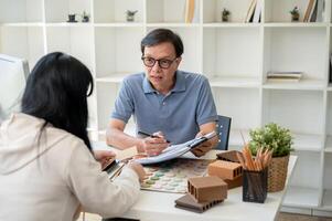 une Masculin intérieur designer ou architecte est ayant une réunion avec le sien client dans le bureau. photo