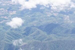 aérien vue de montagnes, ciel, et des nuages sont vu par le avion fenêtre photo