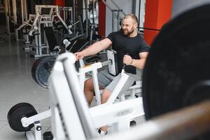 Jeune Beau homme engagé dans le salle de sport. photo