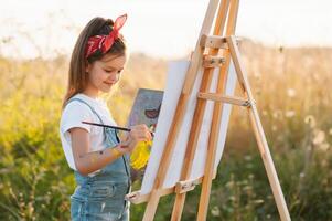 peu fille est La peinture image en plein air. photo