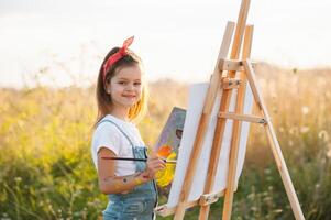 peu fille est La peinture image en plein air. photo