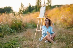 jolie talentueux femelle peintre La peinture sur chevalet, fabrication coloré croquis, création Marin paysage. magnifique femelle artiste La peinture avec aquarelle des peintures. la créativité et imagination concept photo