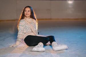 portrait Jeune souriant femme dans blanc chapeau avec patins sur la glace patinoire photo