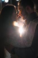 content attrayant couple dans une Noël marché à nuit. magnifique bokeh lumières Contexte. photo