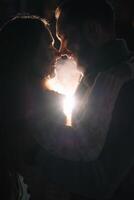 content attrayant couple dans une Noël marché à nuit. magnifique bokeh lumières Contexte. photo