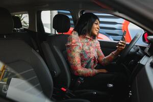 africain américain femme séance dans voiture utilisation mobile téléphone envoyer des SMS tandis que conduite dangereux photo