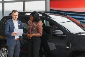 femme achat le auto. Dame dans une voiture salon. élégant noir fille photo