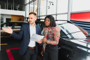 femme achat le auto. Dame dans une voiture salon. élégant noir fille photo