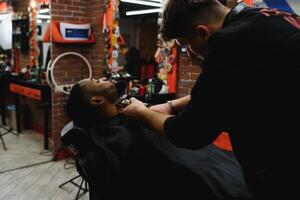 Jeune Afro-américain homme visite salon de coiffure photo