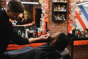 visite salon de coiffure. africain américain homme dans une élégant coiffeur magasin photo