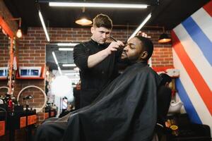 visite salon de coiffure. africain américain homme dans une élégant coiffeur magasin photo