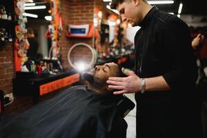 visite salon de coiffure. africain américain homme dans une élégant coiffeur magasin photo