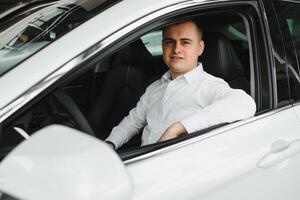 portrait de un Beau souriant affaires homme conduite le sien auto. photo