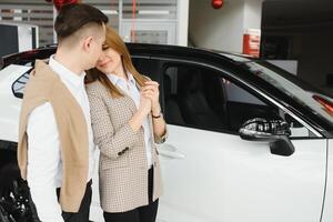 content Jeune couple choisit et achat une Nouveau voiture pour le famille dans le concession photo