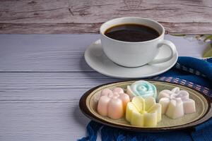 Haut vue de coloré noix de coco Lait gelée sur une assiette sur une bleu tissu avec une blanc café tasse Contexte. concept de thaïlandais dessert et boisson photo