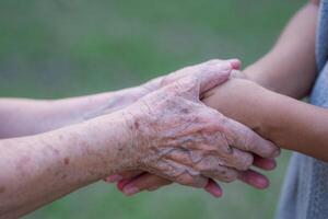 mains de une grand-mère en portant le mains de une petite fille. encouragement concept photo