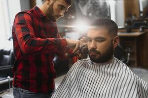 coiffeur magasin. homme avec épouse dans barbier chaise, coiffeur salon de coiffure coiffant le sien cheveux. photo