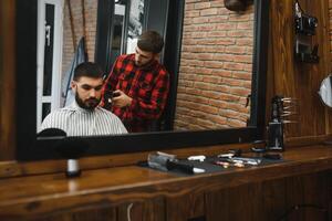 coiffeur magasin. homme avec épouse dans barbier chaise, coiffeur salon de coiffure coiffant le sien cheveux. photo