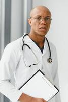 africain américain homme Masculin hôpital médecin dans blanc manteau avec stéthoscope. photo