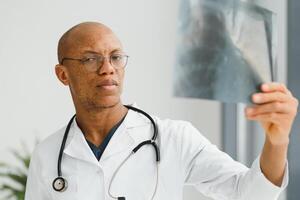 africain médecin à la recherche à une radiographie. photo