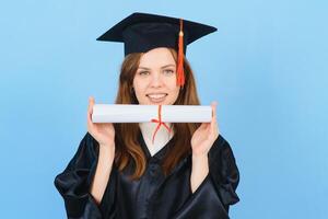 femme diplômé étudiant portant l'obtention du diplôme chapeau et robe, sur bleu Contexte photo