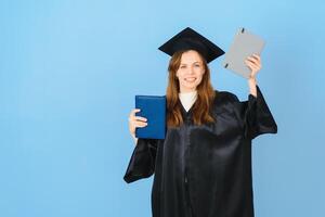 femme diplômé étudiant portant l'obtention du diplôme chapeau et robe, sur bleu Contexte photo