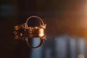 élégant mariage anneaux pour le la mariée et jeune marié sur une noir Contexte avec points forts, macro, sélectif se concentrer. photo