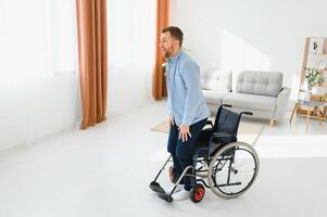 je suis gratuit. homme avoir en haut de fauteuil roulant et jeter une façon le sien en marchant canne photo