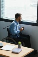 désactivée la personne est assis dans fauteuil roulant contre la fenêtre. sérieux triste caucasien homme portant décontractée vêtements et Regardez à grand panoramique vue dans brillant moderne vivant pièce ou hôpital. photo