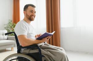 homme dans fauteuil roulant en train de lire une livre à Accueil photo