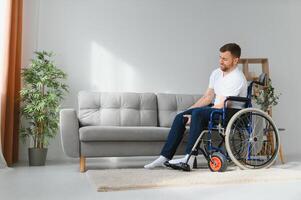 désactivée homme à Accueil essaie à avoir à le sien pieds dans une fauteuil roulant. le concept de réhabilitation après blessures et voiture les accidents. photo