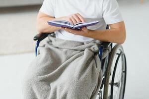 homme dans fauteuil roulant en train de lire une livre à Accueil photo